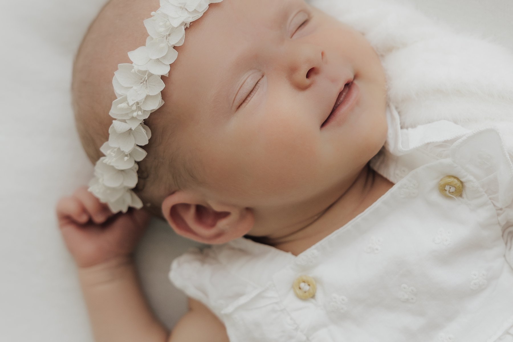 Sleeping newborn with a flower crown in the studio in Sande