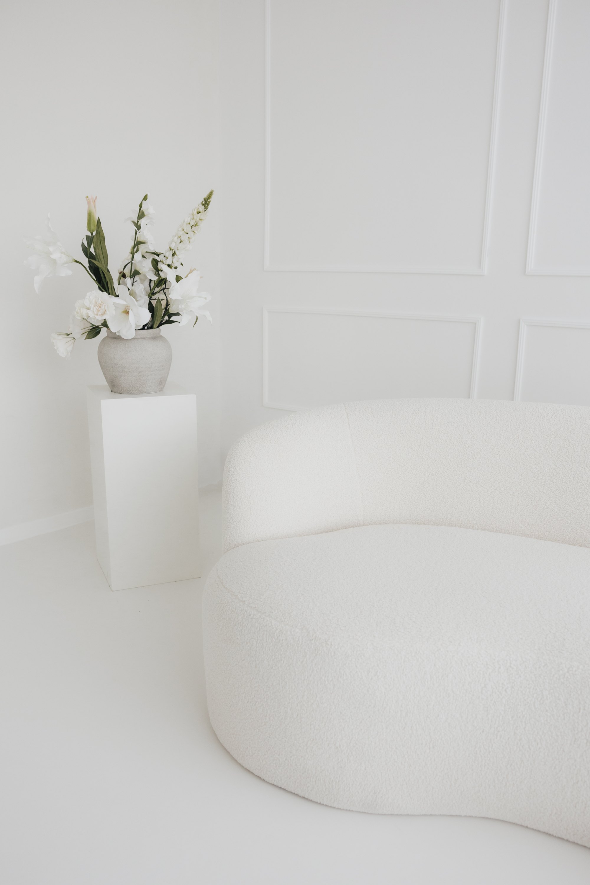 Bright daylight studio in Sande with bouclé sofa and flowers