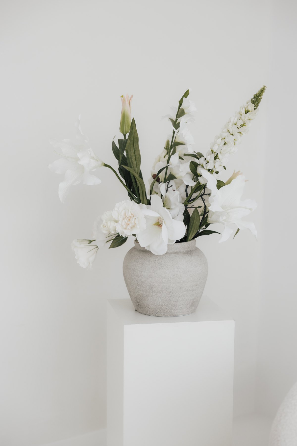 White flowers in a stone vase in the bright daylight studio